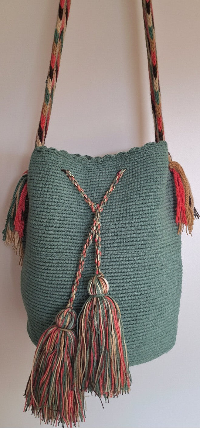 Detailed view of traditional Wayuu crochet technique and tassels on a green mochila bag with crossbody strap fully extended. Ethically and responsibly sourced.
