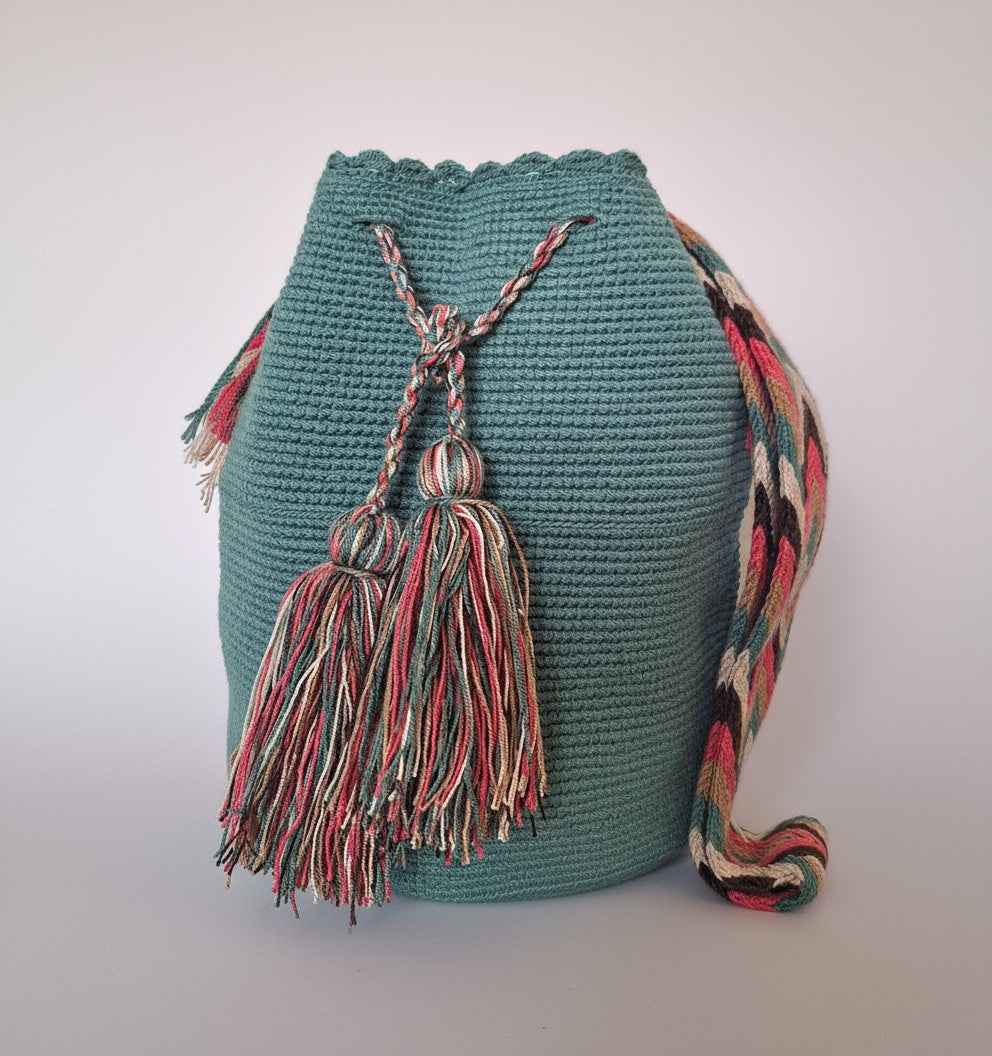 Detailed view of traditional Wayuu crochet technique with tassels on a green mochila bag. Ethically and responsibly sourced.