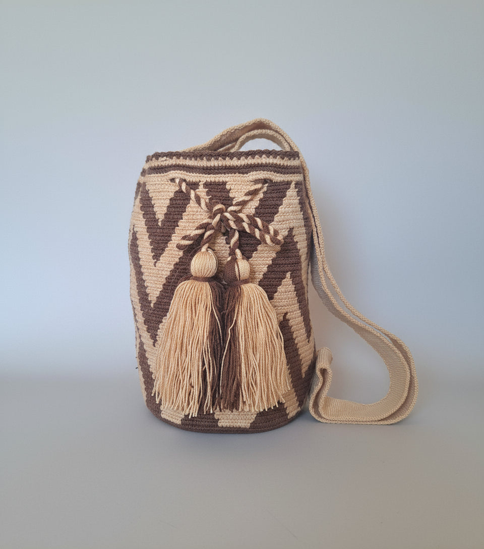 Medium-sized authentic handmade Colombian Wayuu Mochila with zigzag design in brown and beige. Bag is ethically sourced for a conscious boho wardrobe.