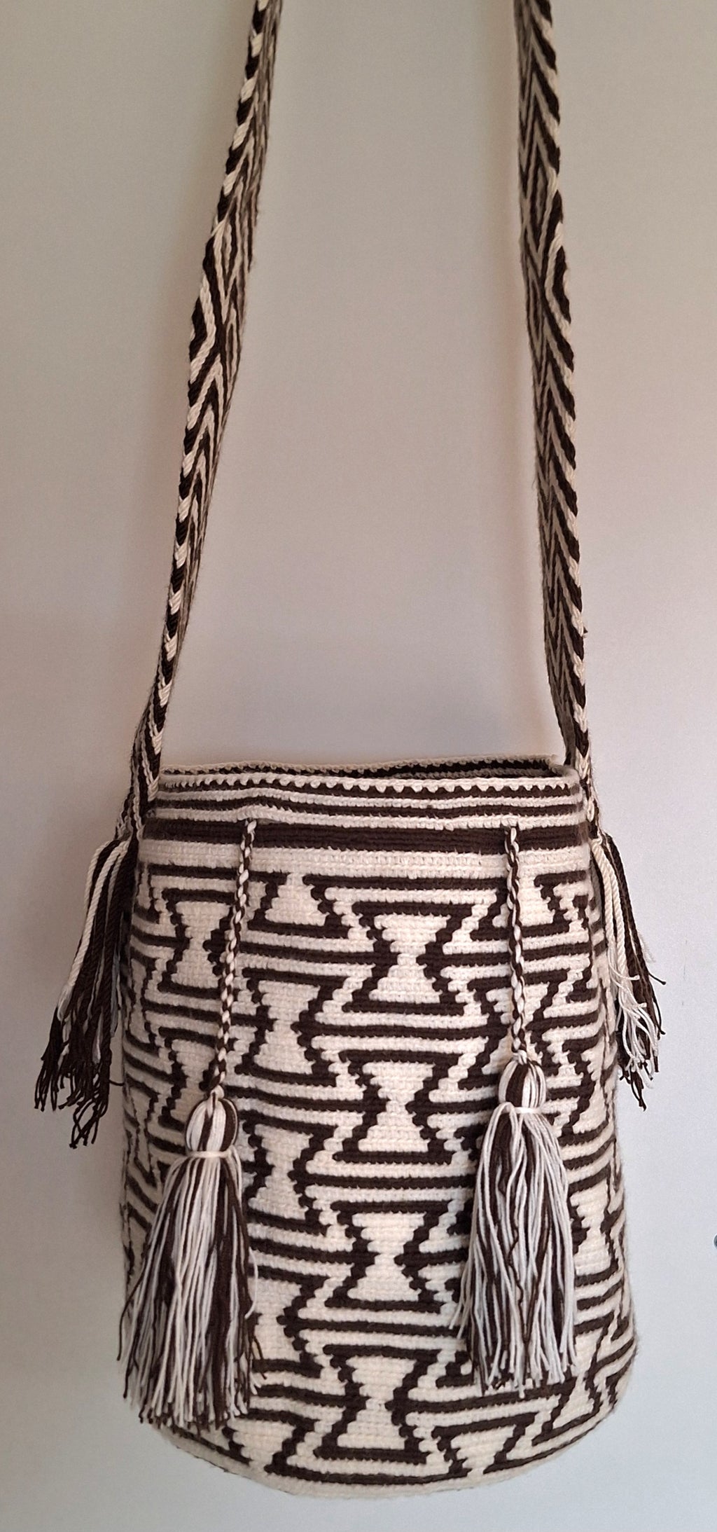 Detailed view of traditional Wayuu crochet technique and tassels with Geometric Design in Black and White and crossbody strap fully extended. Large mochila is a ethically made, high-quality boho accessory.