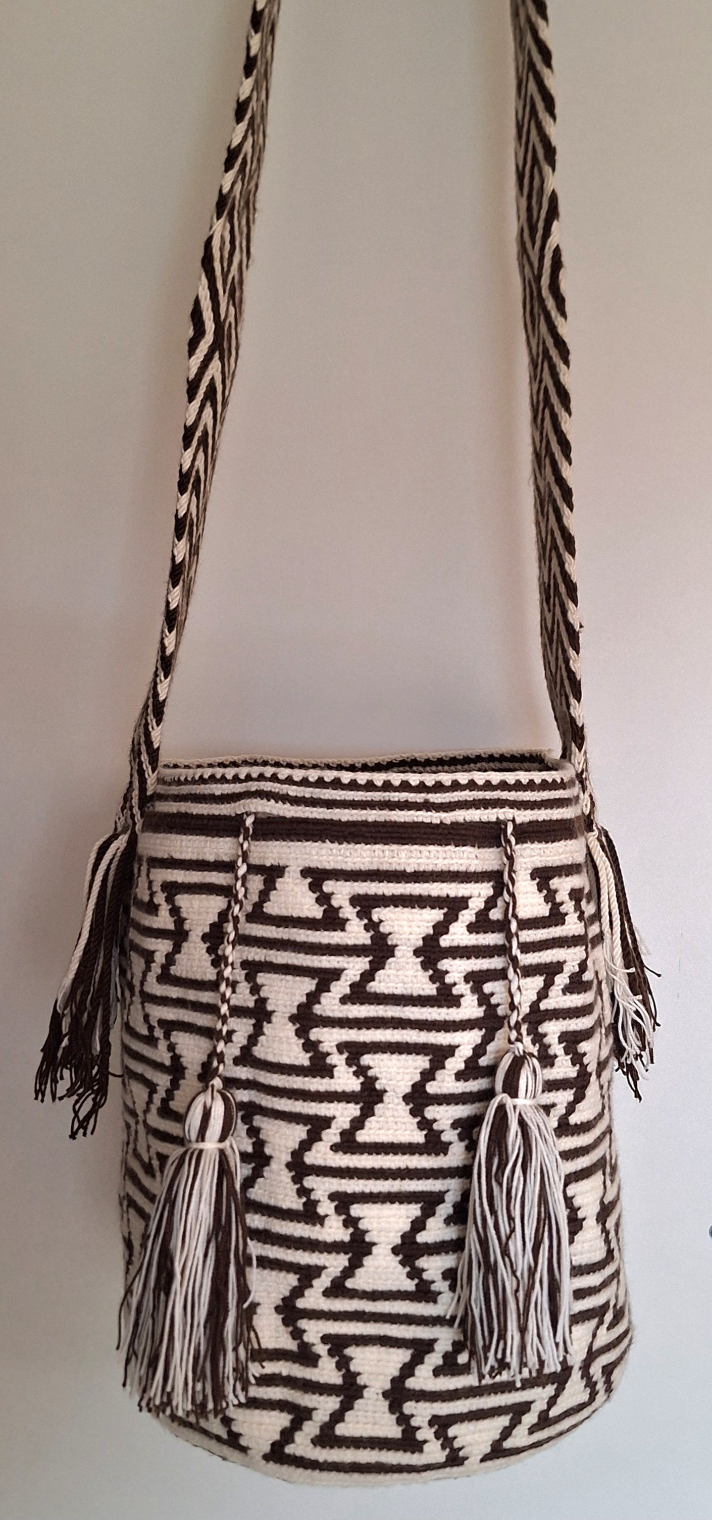 Detailed view of traditional Wayuu crochet technique and tassels with Geometric Design in Black and White and crossbody strap fully extended. Large mochila is a ethically made, high-quality boho accessory.