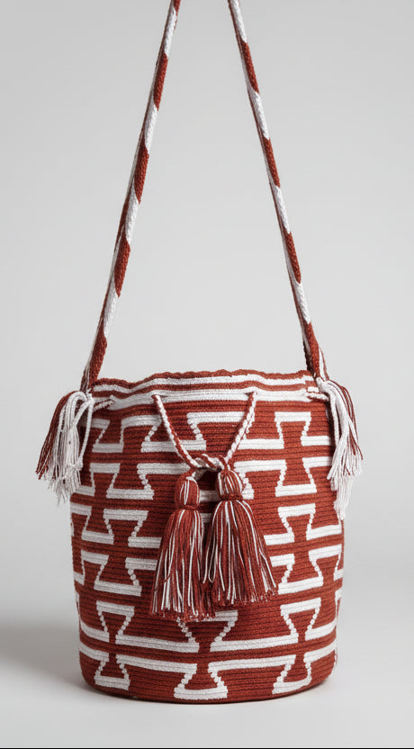 Detailed view of traditional Wayuu crochet technique and tassels on a mochila bag in red and white. Ethically and responsibly sourced.