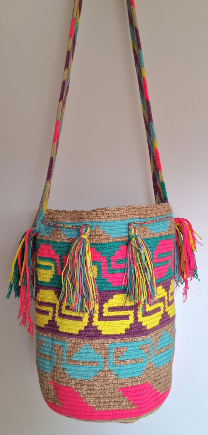 Detailed view of traditional large Wayuu Bag Unique Serpent Design in Marbled Beige, Pink and Yellow with colourful tassels and crossbody strap fully extended. Bag is traditionally crafted; adds a tribal touch to boho fits.