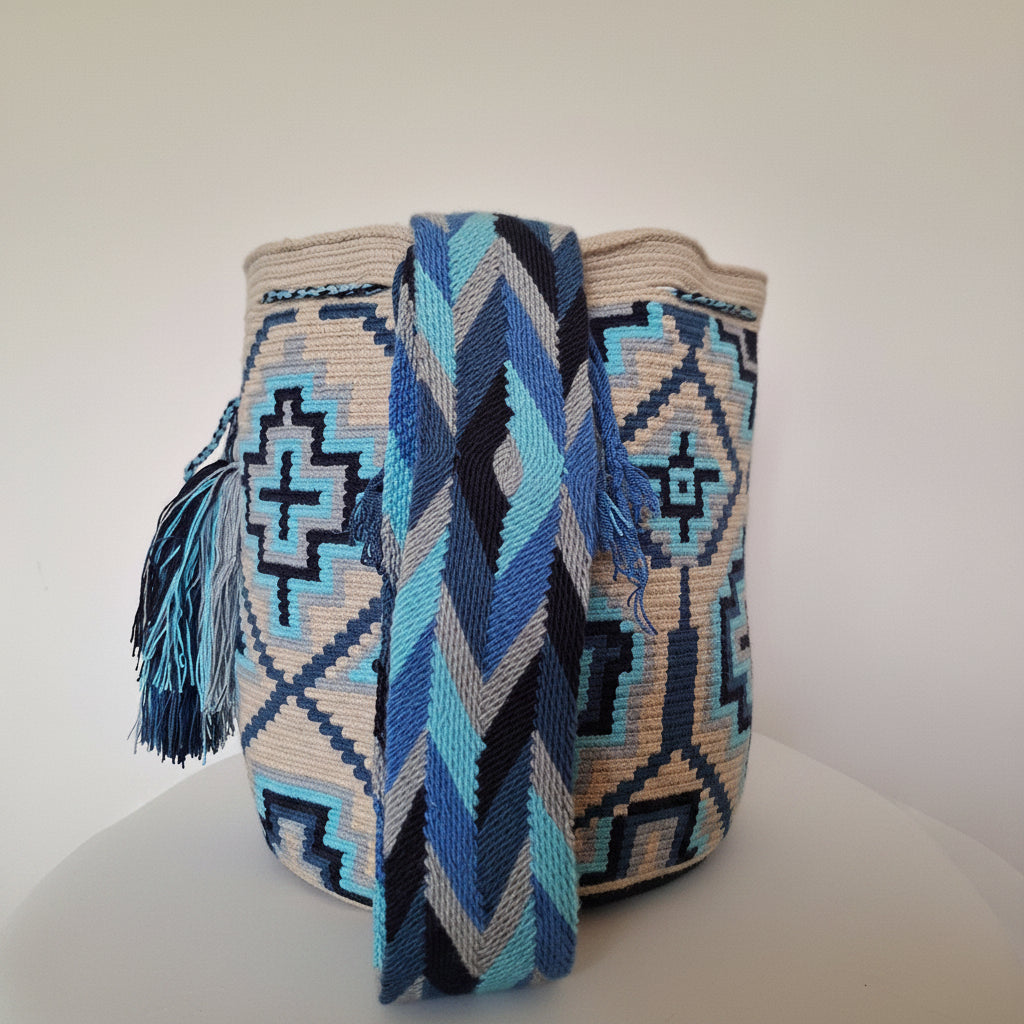 Detailed view of traditional Wayuu crochet technique and tassels on a mochila bag with matching strap at forefront. Ethically sourced for your ideal festival look.
