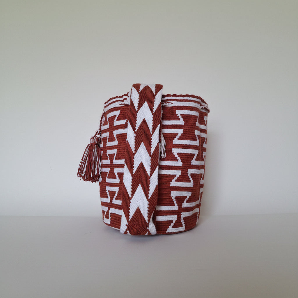 Detailed view of traditional Wayuu crochet technique and tassels on a mochila bag. Emphasis on detail of the matching strap. Ethical mochila handwoven.
