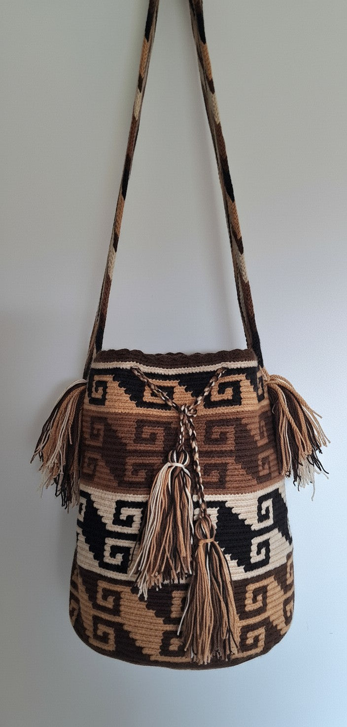 Detailed view of traditional Wayuu crochet technique and tassels on a brown and beige mochila bag with crossbody strap fully extended. Ethically and responsibly sourced.
