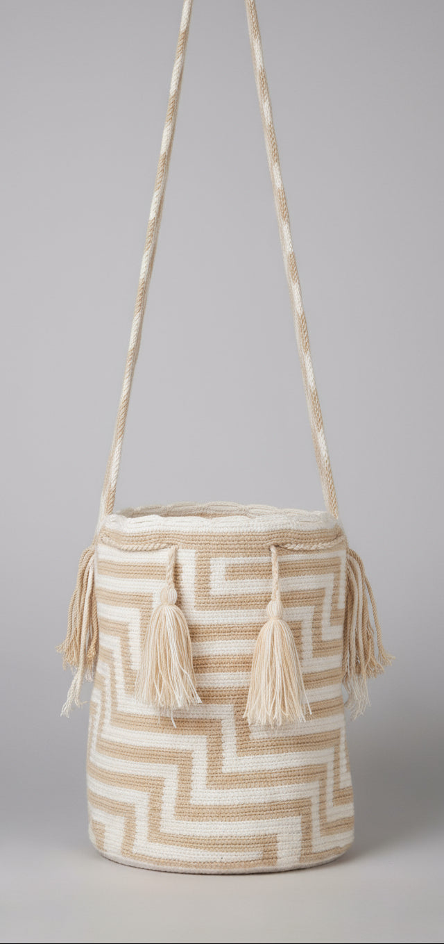 Detailed view of traditional Wayuu crochet technique and tassels on a mochila bag with crossbody strap fully extended. Ethically and responsibly sourced. Beige and Cream
