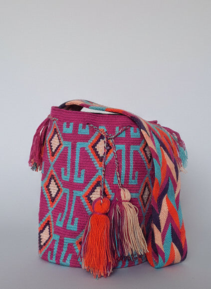 Authentic handmade Colombian Wayuu Mochila in pink and blue cotton threads, geometric design, showing crossbody strap. Ethically and responsibly sourced.