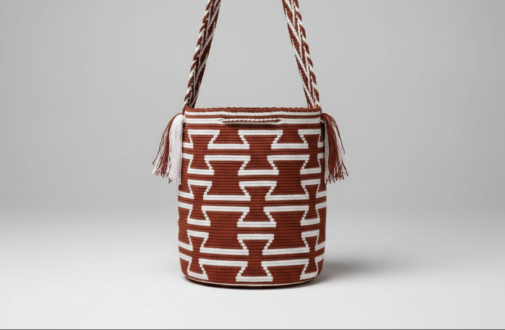 Authentic handmade Colombian Wayuu bag in vibrant cotton threads, geometric design in red and white. Detailed view of traditional Wayuu crochet technique and tassels on a mochila bag. Ethically and responsibly sourced.