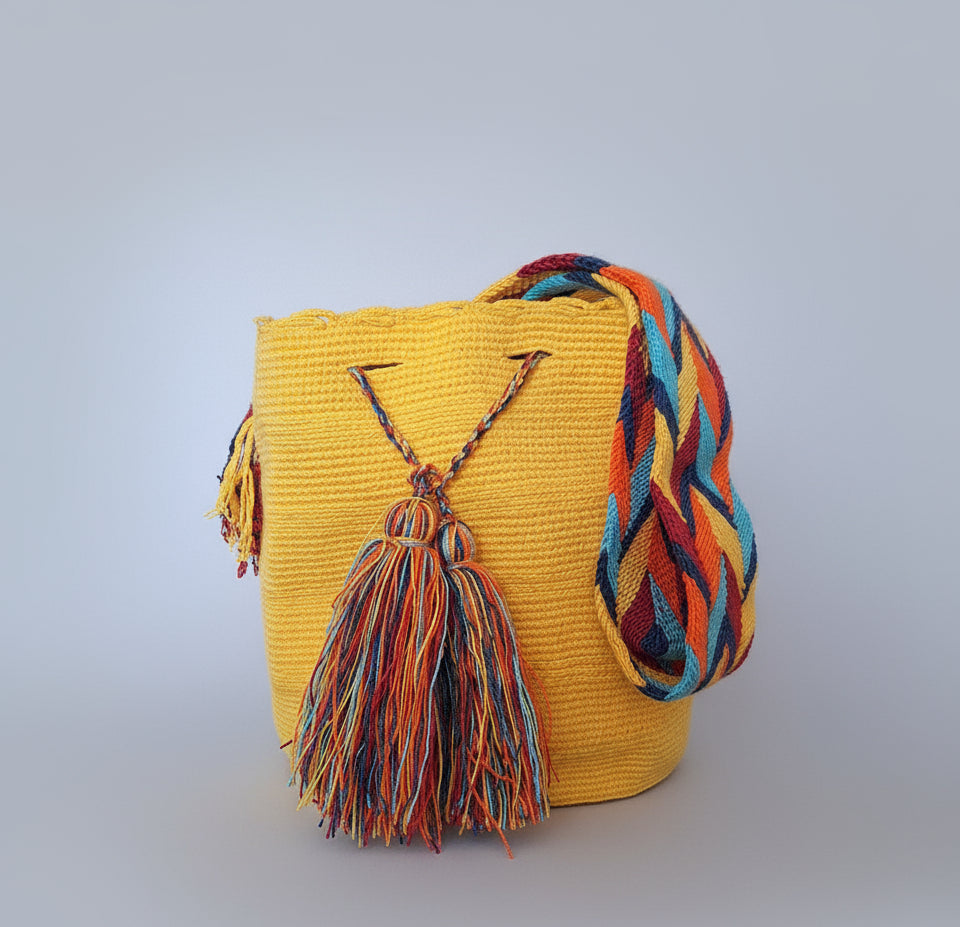 Authentic handmade Colombian Wayuu Mochila in vibrant, bright yellow cotton threads with colourful tassels and strap. Bag is authentic Wayuu heritage, ideal for eclectic outfits.