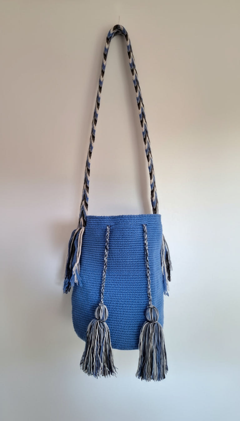Detailed view of traditional Wayuu crochet technique in electric blue with tassels and crossbody strap fully extended. Large mochila bag is authentic Wayuu heritage, ideal for eclectic outfits.
