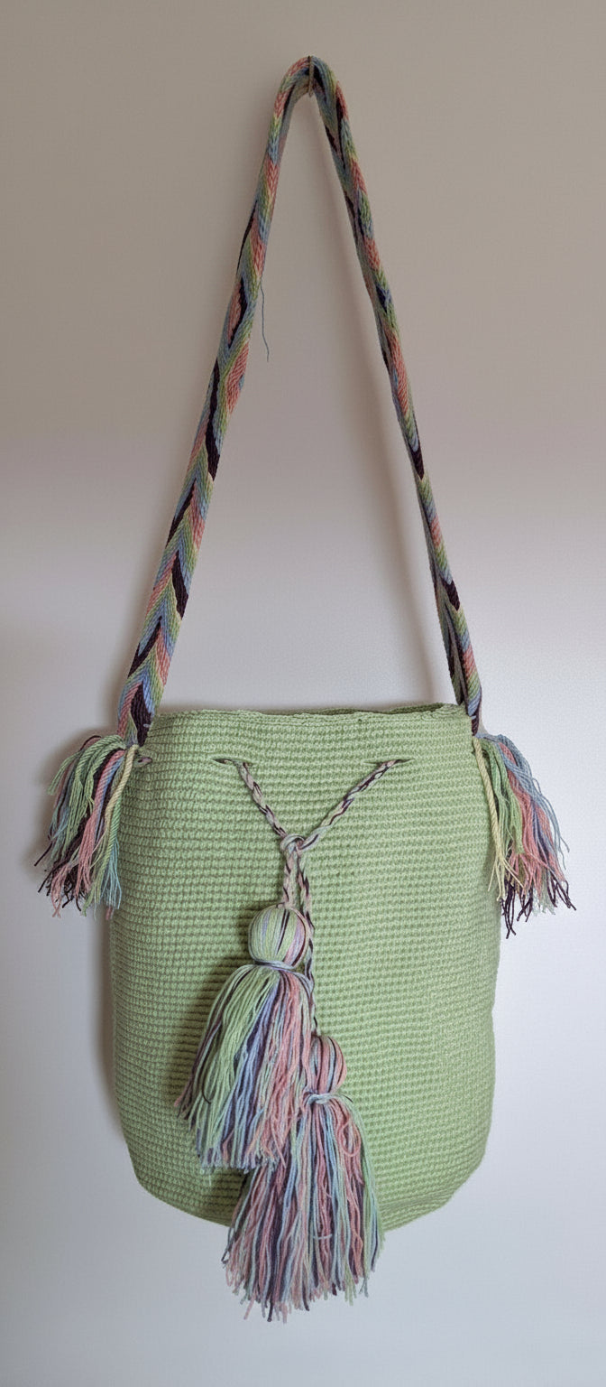 Detailed view of traditional lime green Wayuu bag with and tassels crossbody strap fully extended. Mochila supports  indigenous weavers with every boho purchase.
