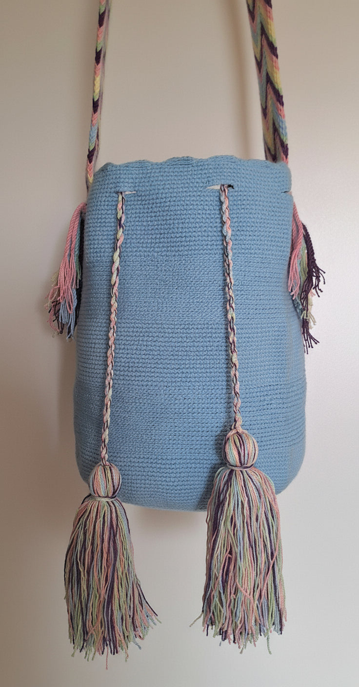 Detailed view of traditional Wayuu crochet technique in sky blue with tassels and crossbody strap fully extended.