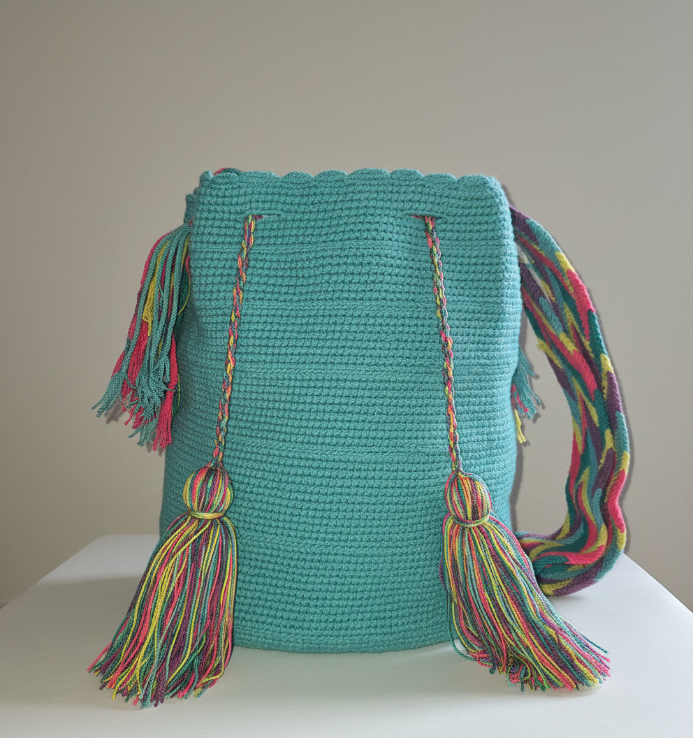 Authentic handmade Colombian Wayuu Mochila in vibrant turquoise green cotton threads. Large artisanal bag is artisan-made and perfect for boho styling.