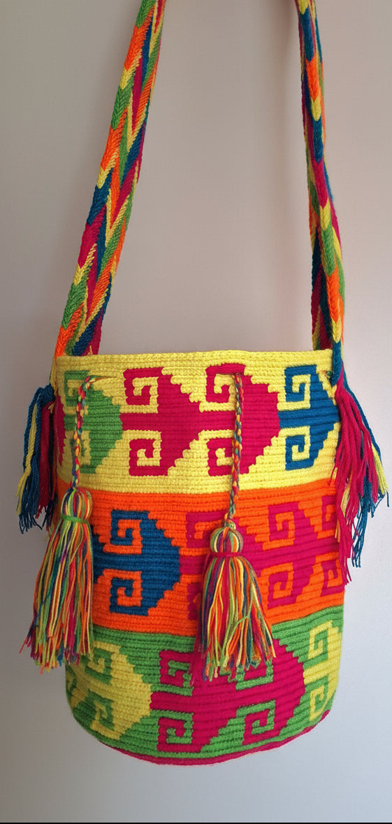 Detailed view of traditional Wayuu crochet technique in yellow, orange and green with tassels and crossbody strap fully extended. Large mochila is unique and ethically sourced for a conscious boho wardrobe. 