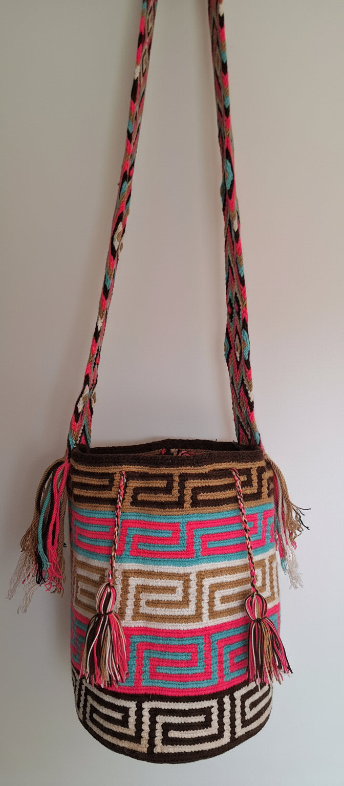 Detailed view of traditional Wayuu crochet technique with labyrinth Design in multiple colours and tassels on a mochila bag with crossbody strap fully extended. Large Wayuu Bag supports indigenous weavers with every boho purchase.