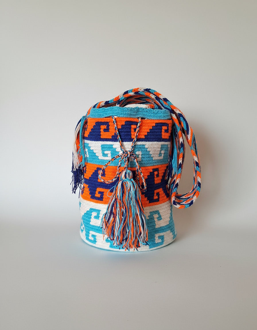 Authentic handmade Colombian Wayuu Mochila in vibrant marine and orange coloured threads, with crashing wave design. Bag is authentic Wayuu heritage, ideal for eclectic outfits.