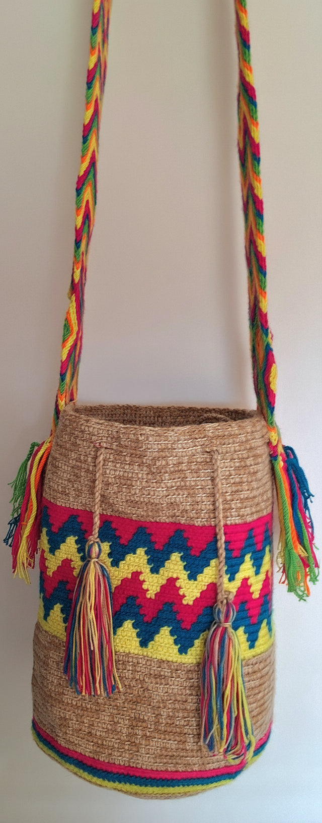 Detailed view of traditional Wayuu in marbled, beige, red, yellow and blue  with and crossbody strap fully extended. Bag supports indigenous weavers with every boho purchase.