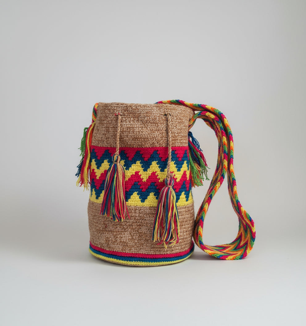 Authentic handmade Colombian Wayuu Mochila in vibrant cotton threads with zigzag design. Bag is sustainably sourced and styled for boho fashion.