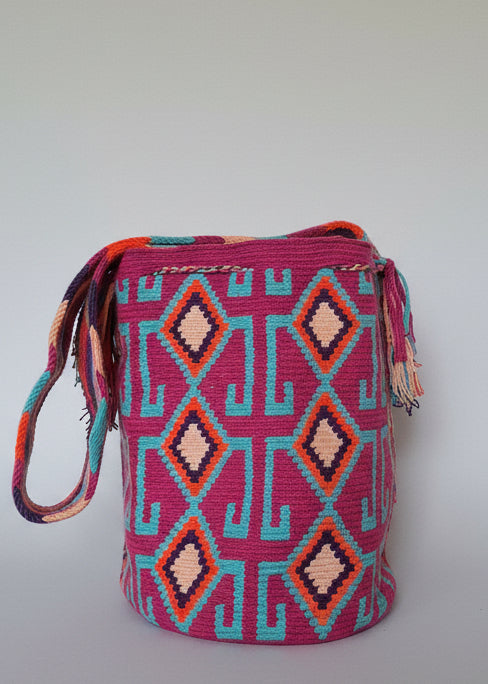 Authentic handmade Colombian Wayuu Mochila in vibrant cotton threads, geometric design in pink and blue. Ethically and responsibly sourced.