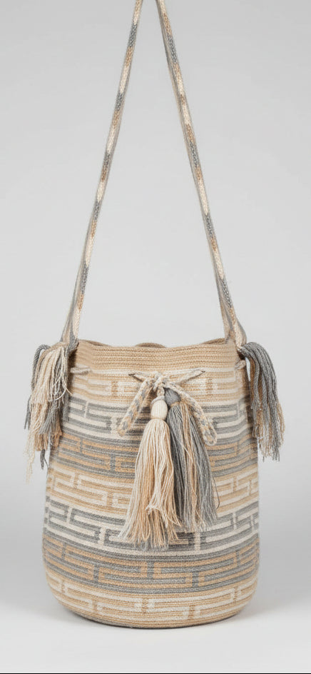 Detailed view of traditional, soft-coloured, Wayuu crochet technique and tassels on a mochila bag. Ethically and responsibly sourced.