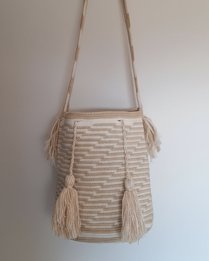 Detailed view of traditional Wayuu crochet technique in soft colours and tassels on a mochila bag with crossbody strap fully extended. Ethically and responsibly sourced.