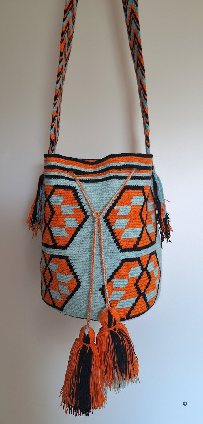 Detailed view of traditional Wayuu crochet technique and tassels on a mochila bag with crossbody strap fully extended. Ethically and responsibly sourced