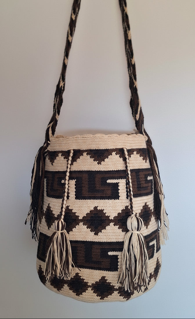 Detailed view of traditional Wayuu crochet technique and tassels on a brown and beige mochila bag with crossbody strap fully extended. Ethically and responsibly sourced.