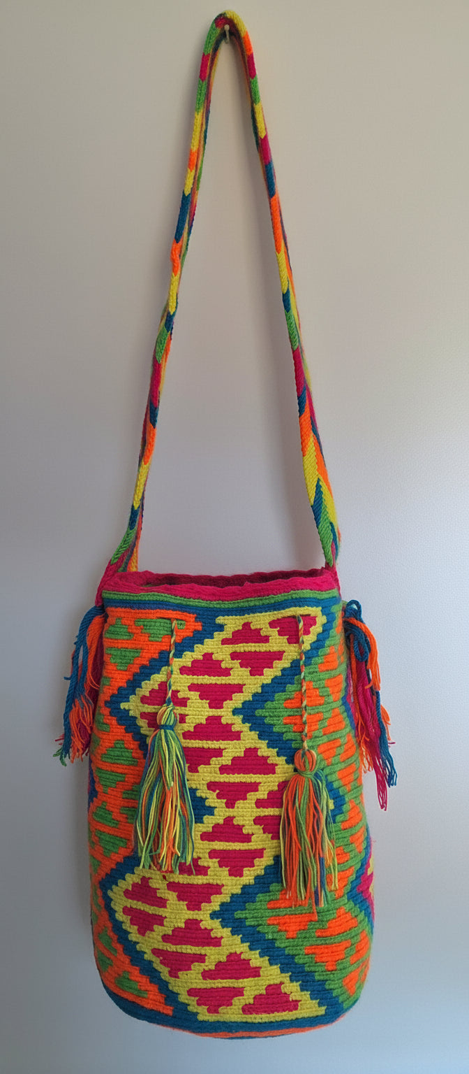 Detailed view of traditional Wayuu crochet technique and tassels on a multicolored mochila bag with crossbody strap fully extended. Ethically and responsibly sourced.