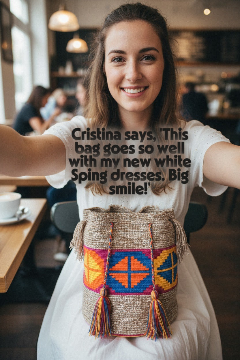Woman with handmade Wayuu shoulder bag with rhombus design in marbled beige, pink, blue, orange and yellow, selfie at café with customer review. Mochila is authentic Wayuu heritage, ideal for eclectic outfits.