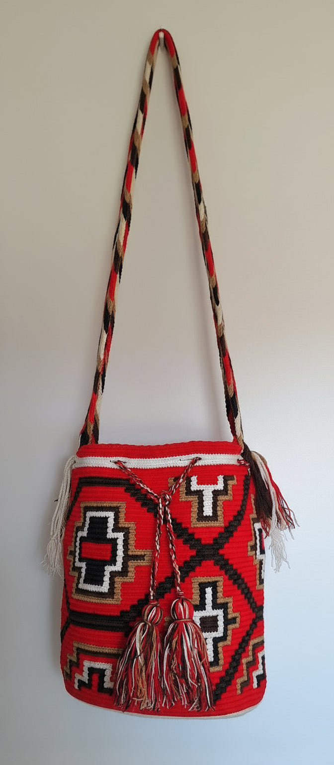 Detailed view of traditional Wayuu kanas on a red and white mochila shoulder bag with crossbody strap fully extended. Ethically and responsibly sourced.